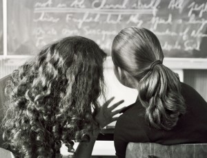 two girls in a classroom looking at the board